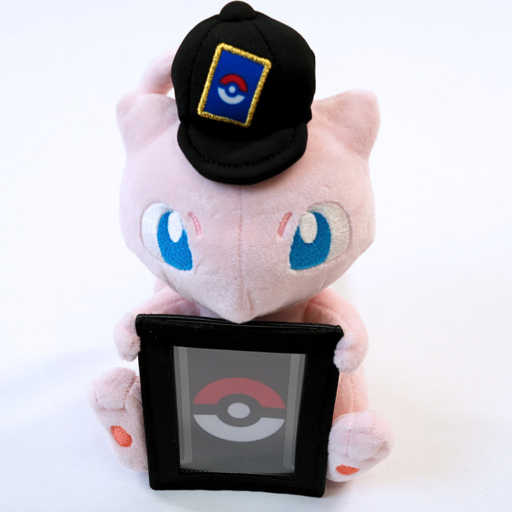 Vista lateral del peluche Pokémon Card Stand Mew, mostrando el perfil de Mew, la gorra y el soporte frontal para carta