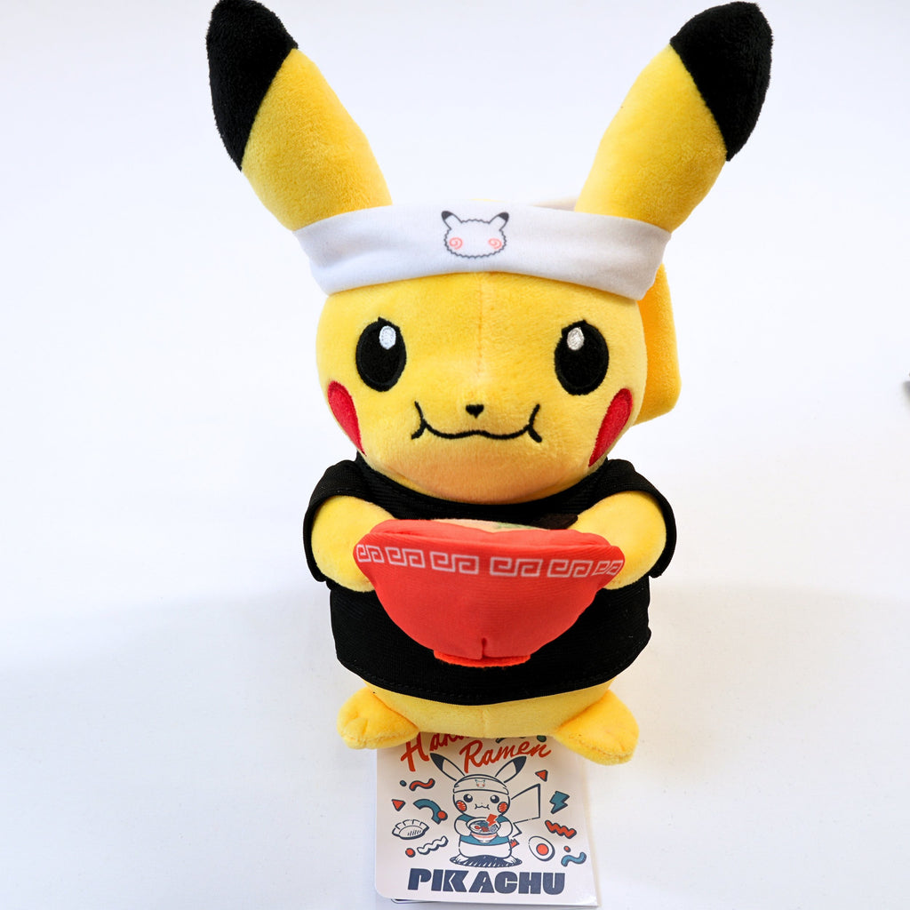 Vista frontal acercada del peluche Pokémon Center Fukuoka R Ramen Pikachu, mostrando a Pikachu con cinta en la cabeza, ropa negra y cuenco de ramen